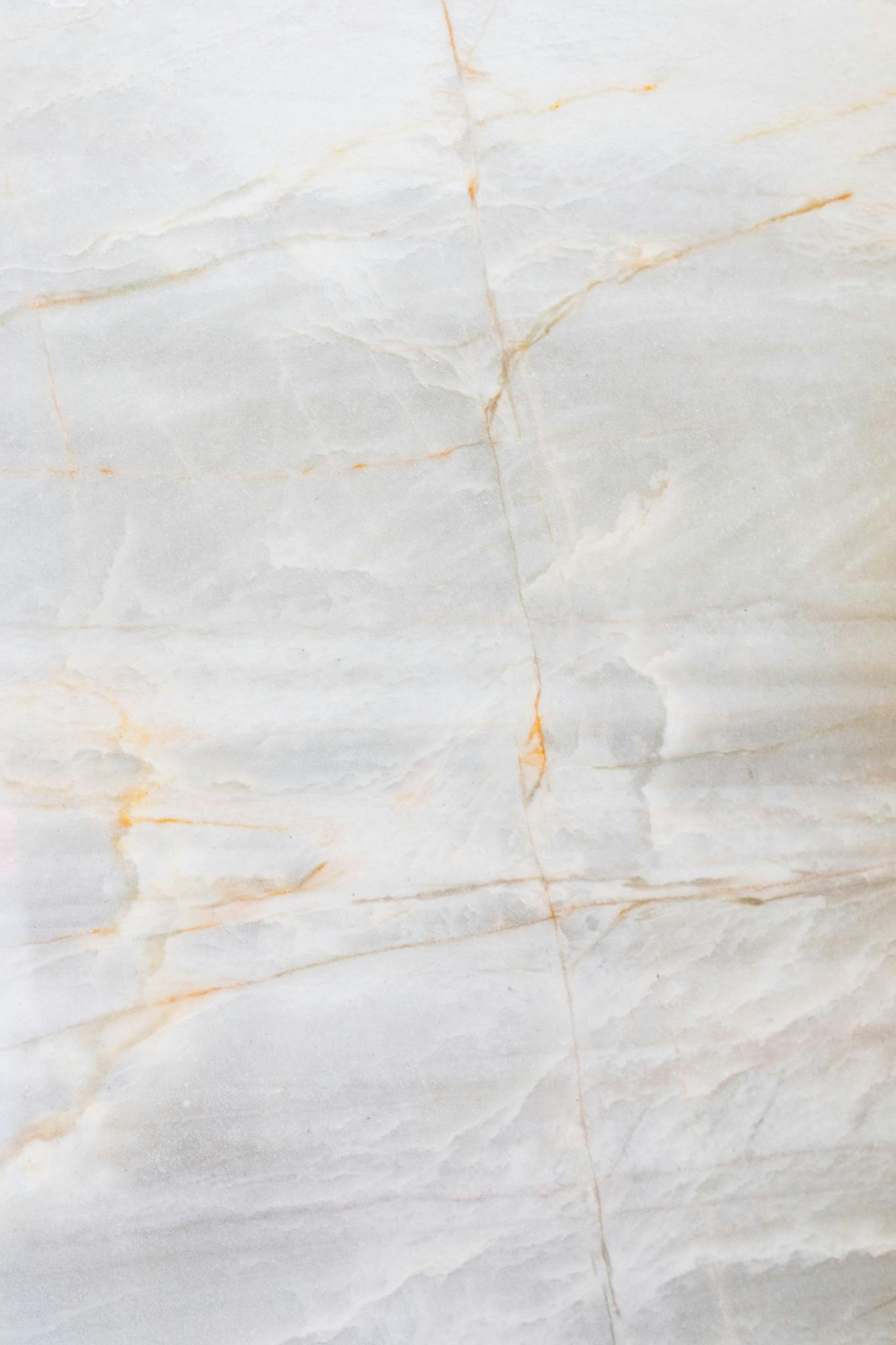 Close-up of a smooth marble surface featuring intricate natural veining and soft tones.